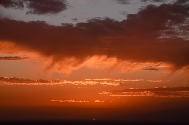 Cloudscape, gekleurde wolken bij zonsondergang in de buurt van de oceaan