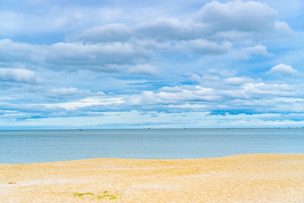 Cloudy blue sky and sea with golden sand beach.