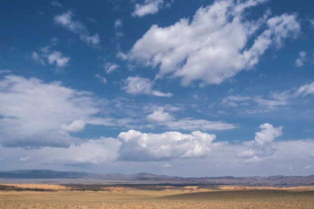 Cloudy sky over the steppe and desert mountains on a hot summer day