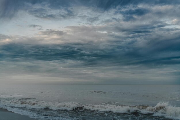 a cloudy sky with the word  on it and the ocean in the background