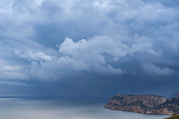 Cloudy and stormy seascape above a cape