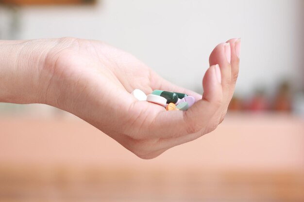 Clouse-up woman with holding pills on on hand