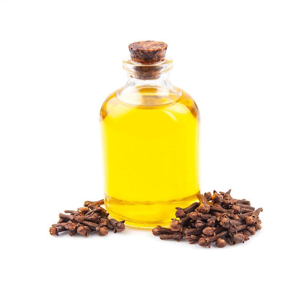 Clove essential oil in bottle and clove seed on white backgrounds