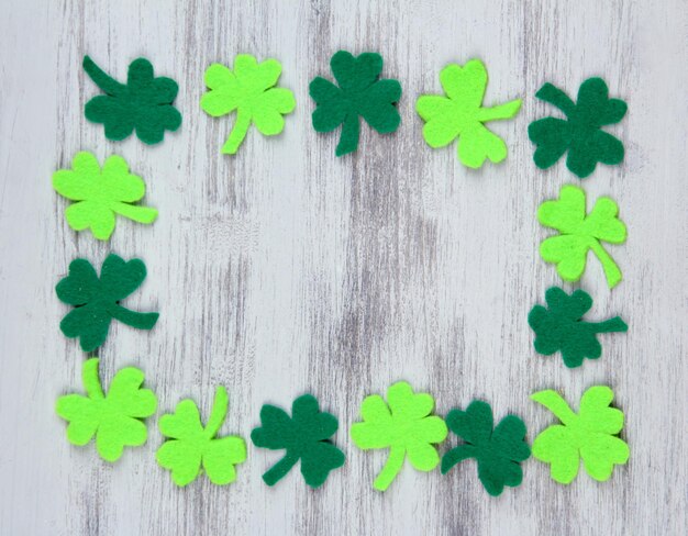 Photo clover leaves on wooden background