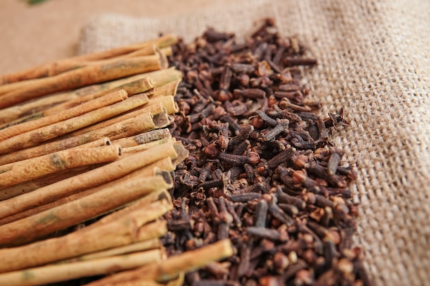 Cloves and cinnamon on burlap sacks and wood