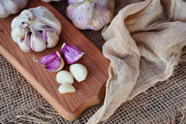 Cloves and heads of garlic on a wooden board rustic style natural eco product