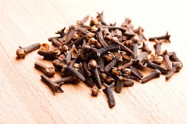 Cloves spice scattered on wooden table