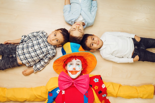 Clown and children pull hands into the camera