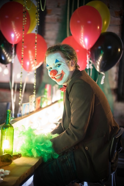 Clown in the dressing room concept a crazy man clown looking in the camera and smiling