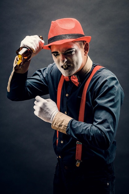 Clown and Halloween theme crazy clown with knife in hand isolated on dark background in Studio