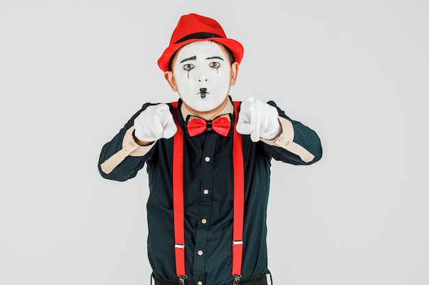 Photo clown with red suspenders and red hat on white background