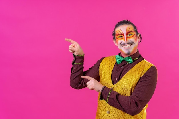 Clown with white facial makeup showing an empty space from the pink background announcing something