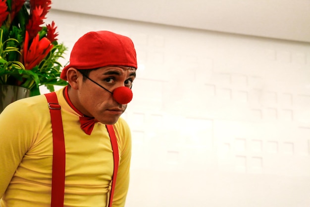 Clown in yellow shirt red cap on white wall