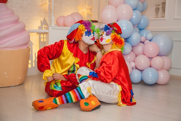 Clownjongen met clownmeisje die pret hebben bij de vakantie