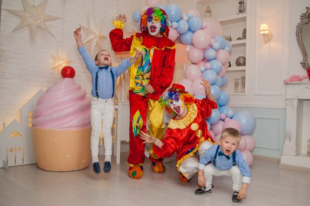 Clownjongen met clownmeisje heeft plezier op het feest met kinderen Kindergeluk