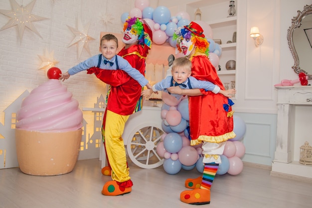 Clownjongen met clownmeisje heeft plezier op het feest met kinderen Kindergeluk