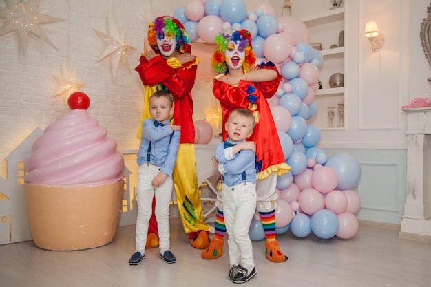 Clownjongen met clownmeisje heeft plezier op het feest met kinderen Kindergeluk