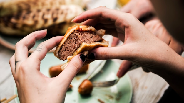 Photo clsoeup of hands holding bite burger