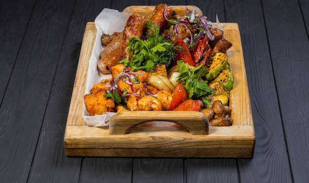 Club Beef steak and Grilled vegetables on board on black wooden