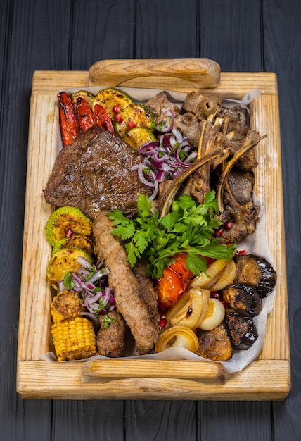 Club Beef steak and Grilled vegetables on board on black wooden