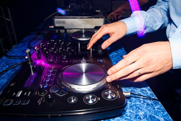 Club DJ mixing music on a mixer in a nightclub