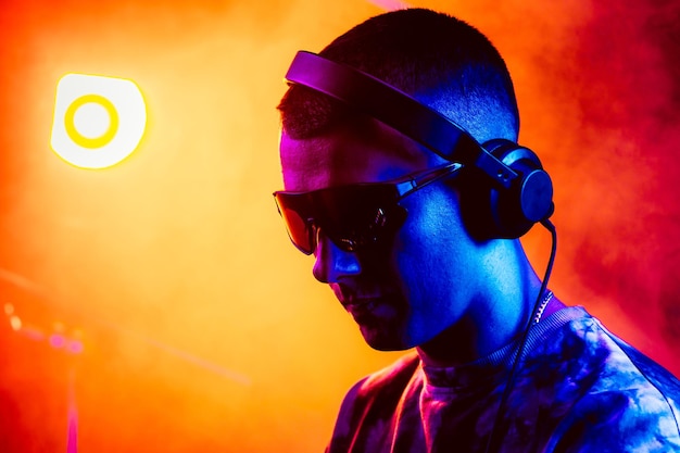 パーティーでサングラスをかぶって音楽を演奏するクラブDJ