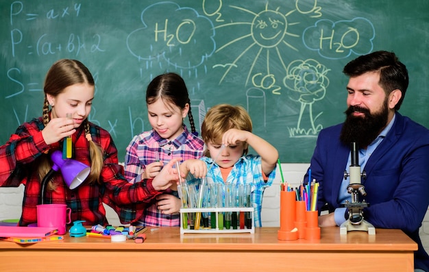 Club include variety of activities with chemistry School club education Teacher and pupils test tubes in classroom Chemistry themed club Topic of our club Group interaction and communication