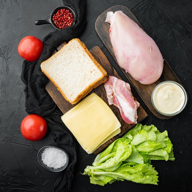 Club sandwich ingrediënten, op zwarte achtergrond, bovenaanzicht