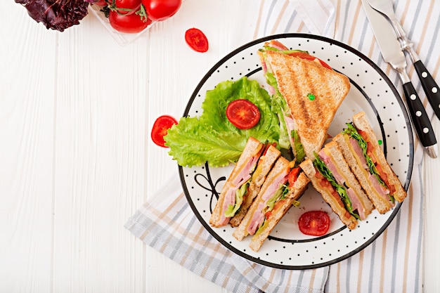 Club sandwich - panini met ham, kaas, tomaat en kruiden. Bovenaanzicht