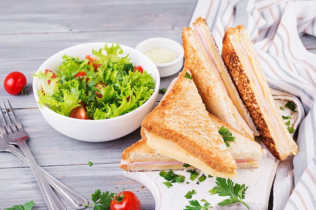 Panini club sandwich con prosciutto, formaggio e insalata. gustosa colazione