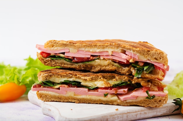 Panini sandwich club con prosciutto, pomodoro, formaggio e lattuga