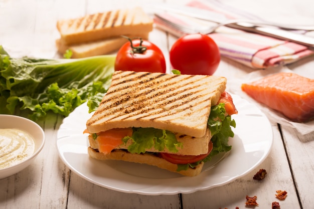 Club sandwich prepared with fish on the wooden board