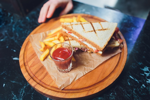 Club Sandwich with Cheese, PIckled Cucmber, Tomato and Smoked Meat. Garnished with French Fries.