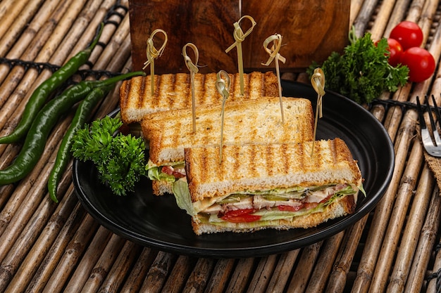 Club sandwich with chicken tomato cheese and salad