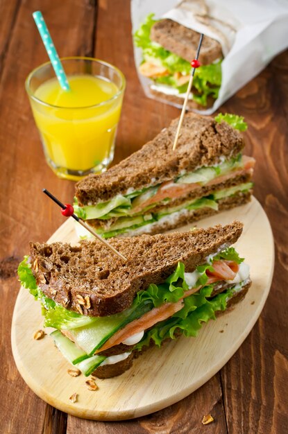 Club sandwich with salmon and cucumbers