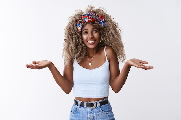 Clueless and unbothered good-looking blond curly-haired female with headband, piercing shrugging indifferent and unaware, have no answer, cannot tell what happened, smiling silly