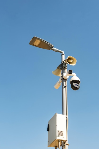 Cluster of security cameras on a lamppost in an public Park on the sky background with copy space