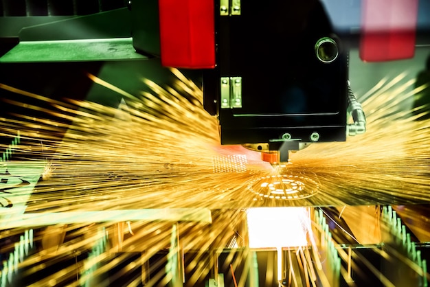 CNC Laser cutting of metal, modern industrial technology. Small depth of field. Warning - authentic shooting in challenging conditions. A little bit grain and maybe blurred.