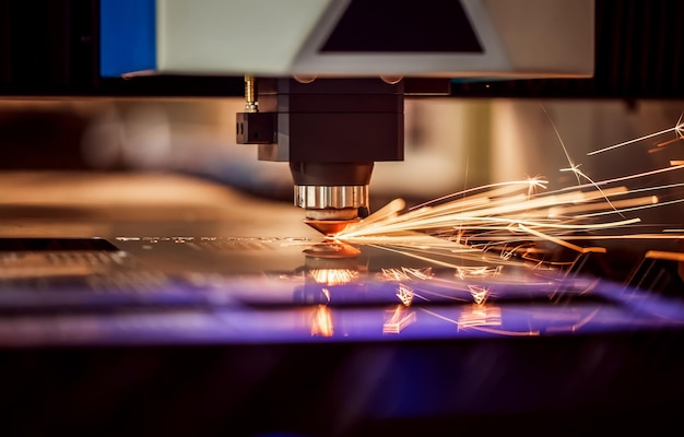 CNC lasersnijden van metaal, moderne industriële technologie. Kleine scherptediepte. Waarschuwing - authentiek fotograferen in uitdagende omstandigheden.