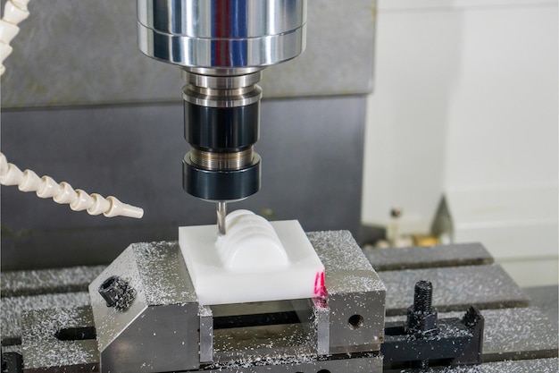 Foto la fresatrice cnc taglia con precisione elevata le parti in plastica con lo strumento di finitura a sfera solida il processo di taglio di attrezzi e apparecchiature con il centro di lavorazione con gli strumenti di finitura con sfera solida