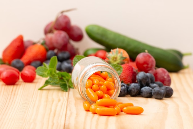 Photo co q 10 viitamins supplements in the glass bottle on the wooden table with variety fruit