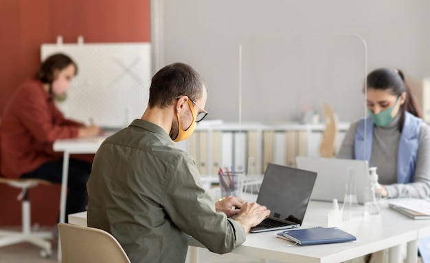 Foto collaboratori che indossano la maschera per il viso in ufficio