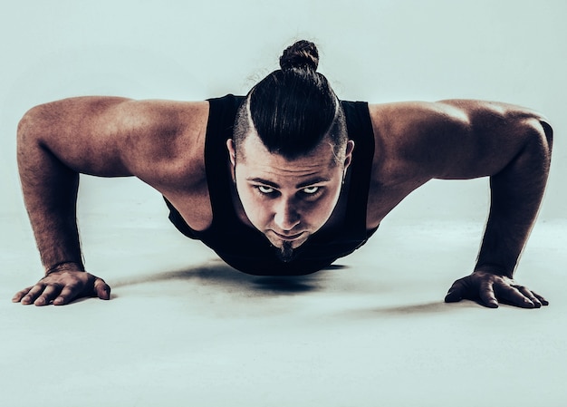 Фото Тренер по бодибилдингу выполняет push-ups. фото на белом фоне