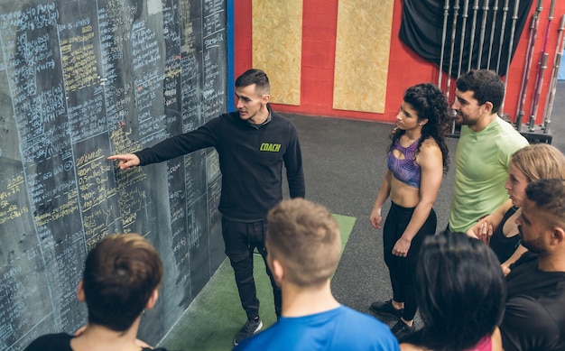 Photo coach explaining to athletes in the gym