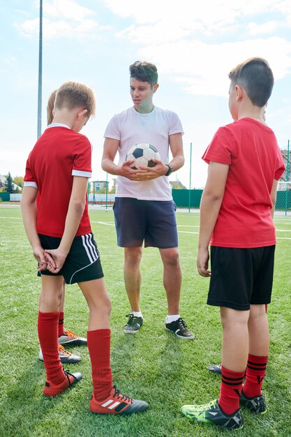 Foto allenatore parlando con la squadra di calcio junior