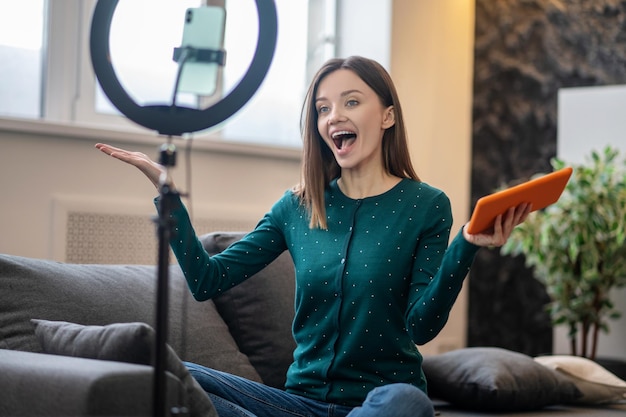 Coachen. Vrolijke jonge vrouw in groen shirt voor camera online workshop maken