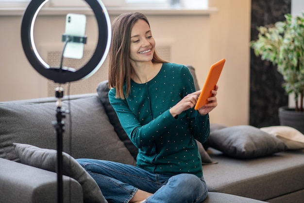 Coaching. Cheerful young woman in green shirt in front of camera making online workshop