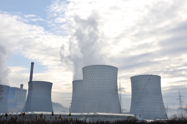 Coal fired power station with cooling towers releasing steam into atmosphere