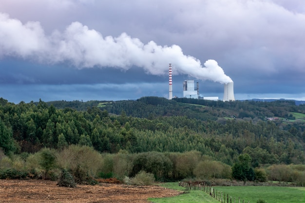 空気を汚染する石炭発電所。厚い煙突が空に向かって喫煙しています。環境汚染問題の概念