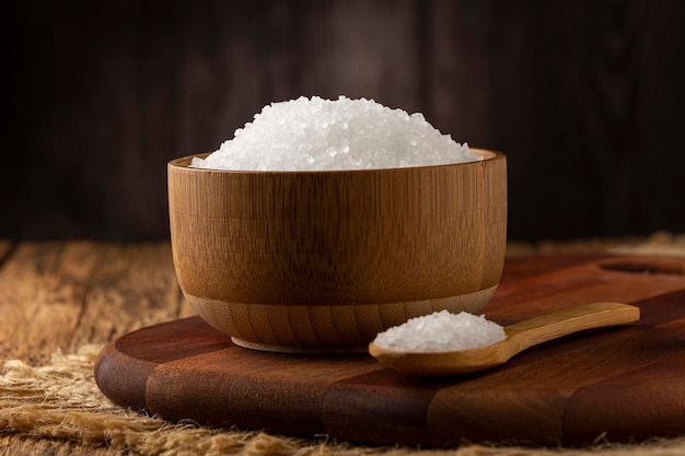 Coarse salt in bowl on wooden background